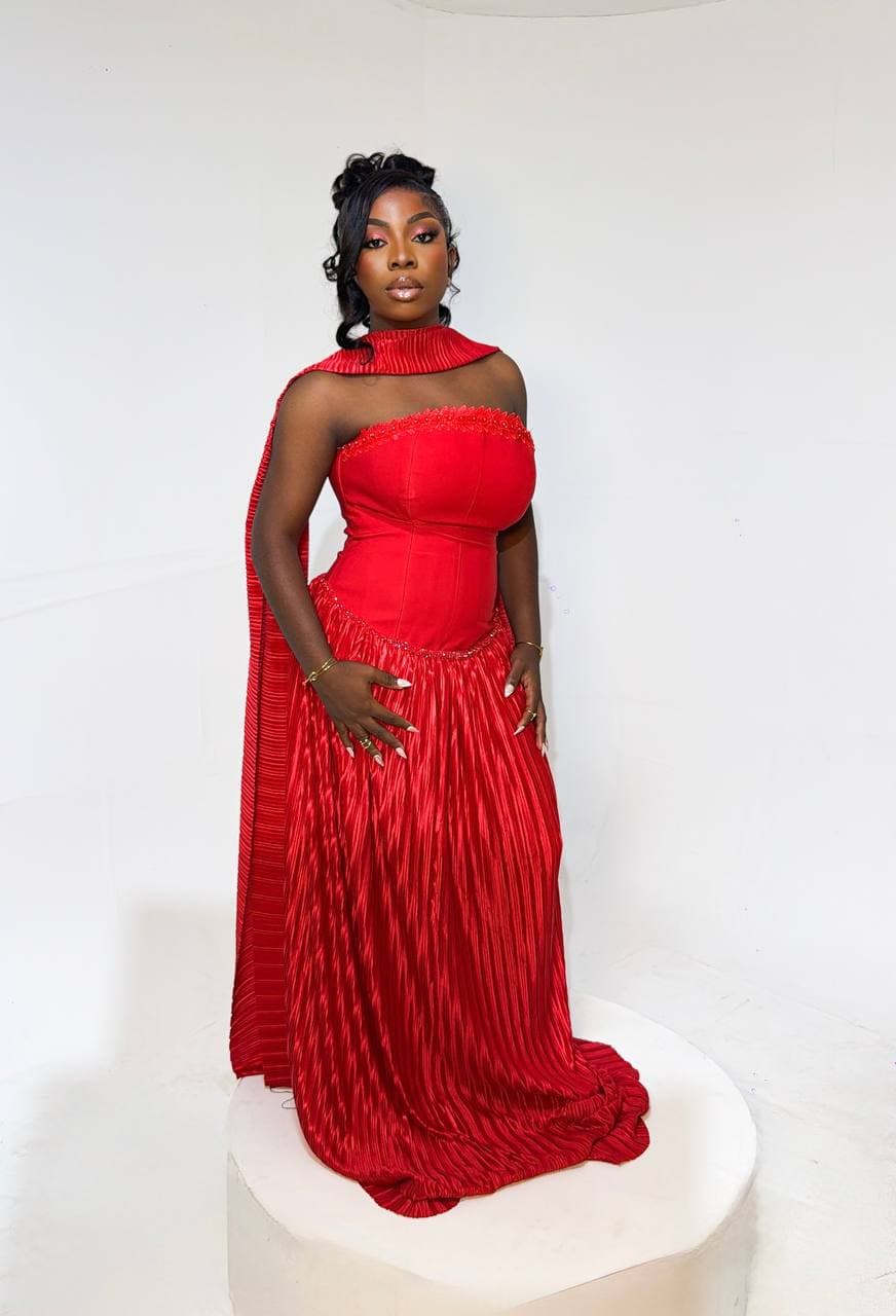 Editorial full-length portrait in a red one-shoulder gown
