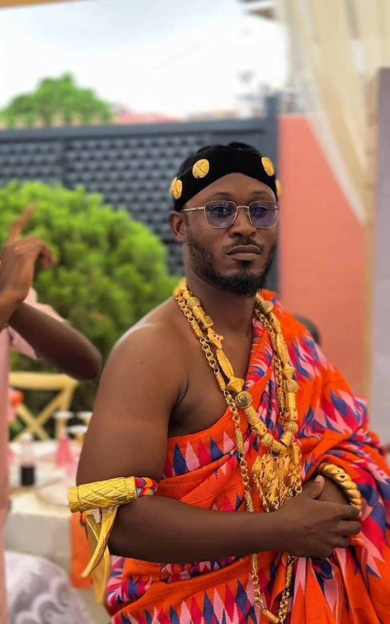 Portrait of a groom in traditional Ghanaian kente and gold regalia