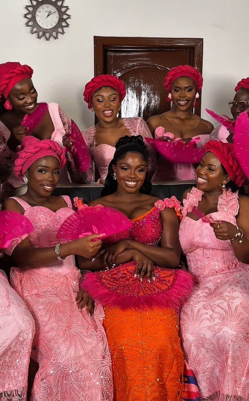 Bridal party group portrait in pink lace gowns and red headwraps