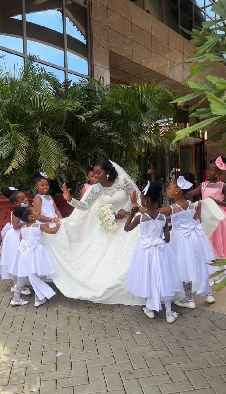 Bride walking with flower girls in white dresses outside the venue